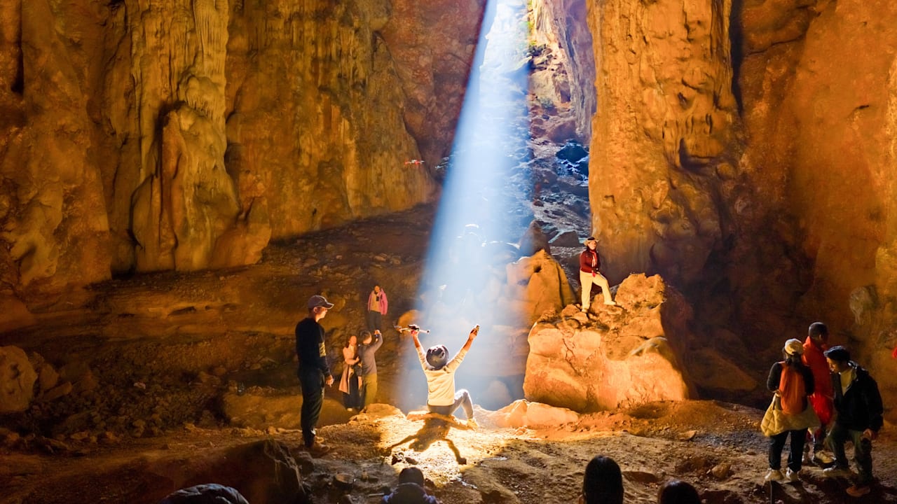 Laibin (China): Sonnenlicht in einer Karsthöhle. Touristen erleben einen Sonnenstrahl, der in