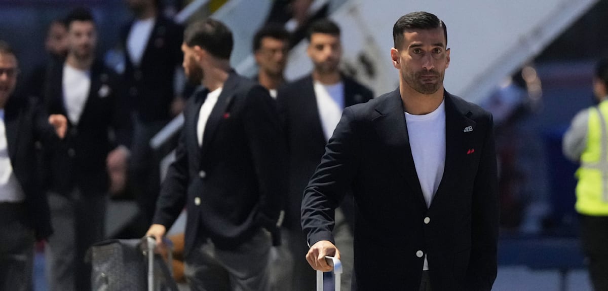 168 – mit einem Ansteckpin erinnern Irans Nationalspieler an Bombenangriff